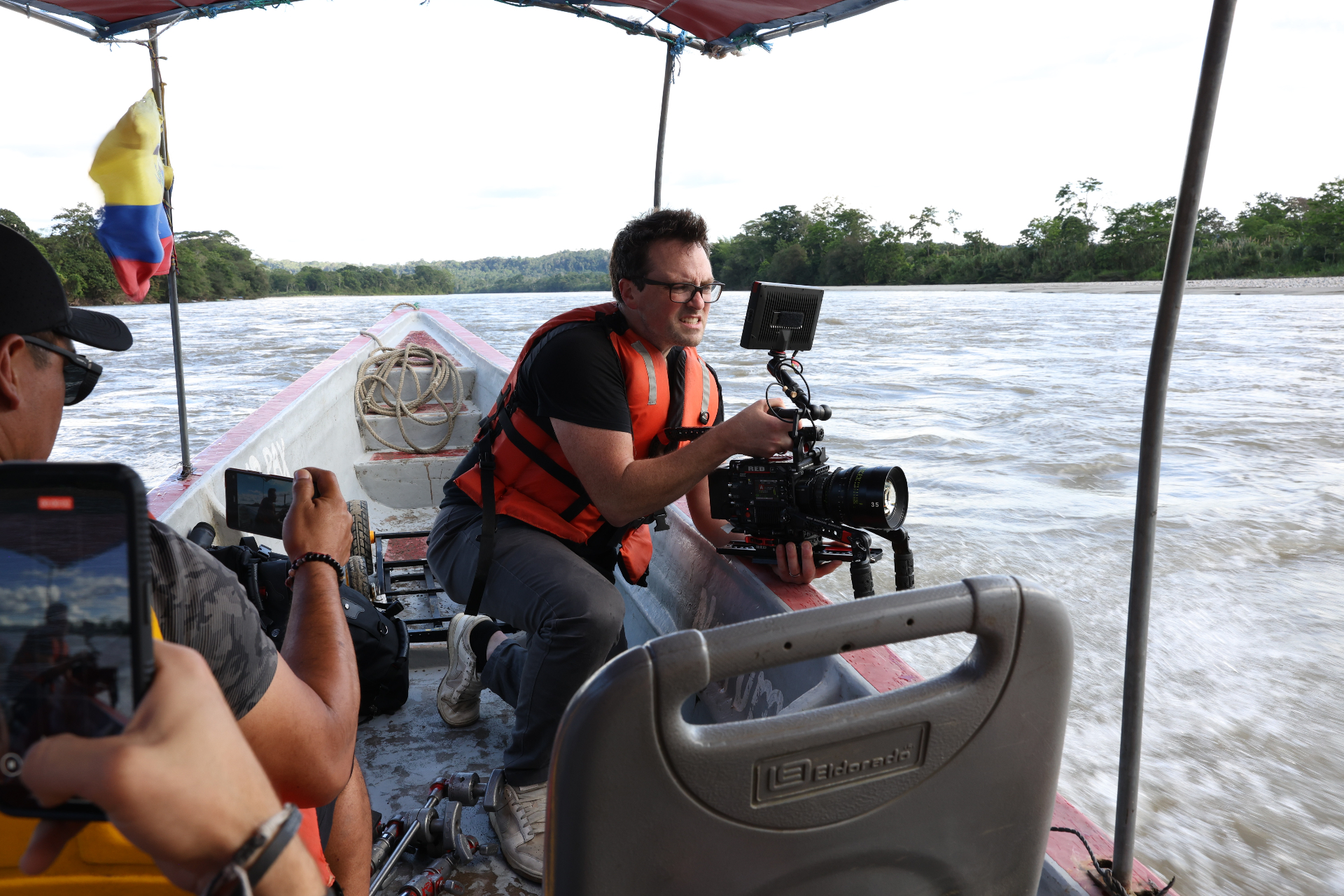 Cinematographer filming on a riverboat in the Ecuadorian Amazon